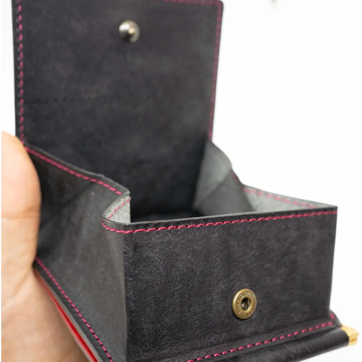 Contrast Stitchの小銭入れ。黒い革に赤いステッチが入っている