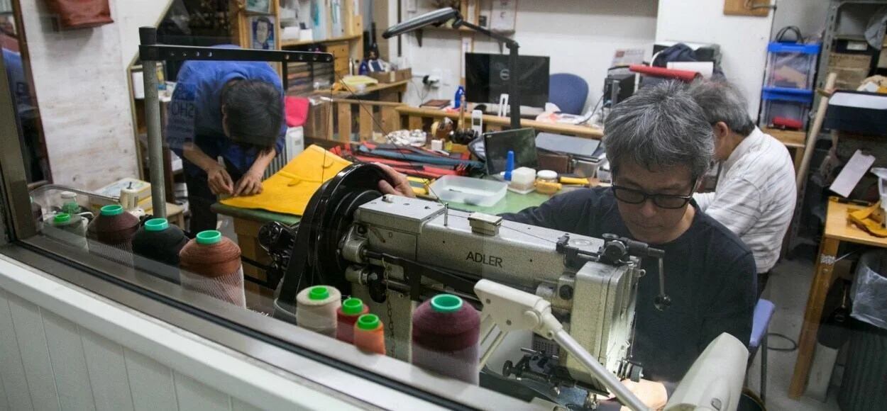 HIS-FACTORY の工房でミシンに向かう職人